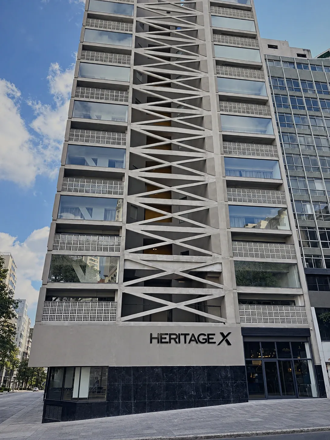 Heritage X façade with the sign and the X-shaped concrete structure, seen from the pavement