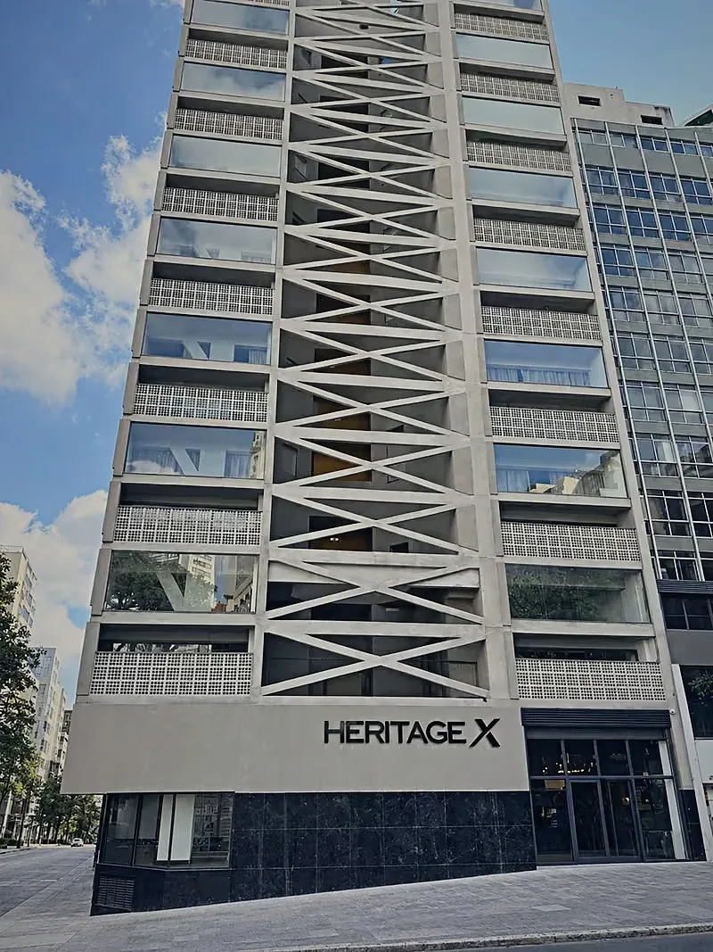 Heritage X façade seen from the pavement, with the sign and the X-shaped concrete structure