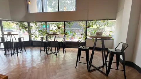Reception and restaurant at Heritage X, with tables, plants and natural light
