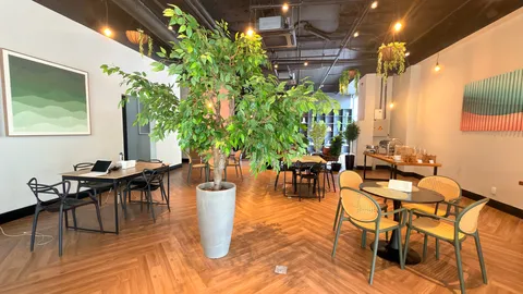 Reception and restaurant at Heritage X, with tables, plants and natural light