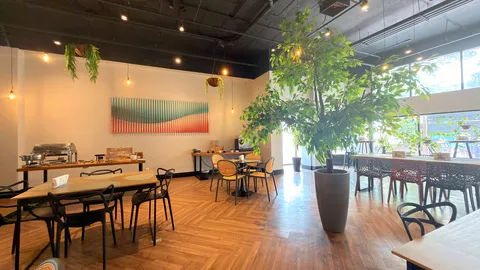 Reception and restaurant at Heritage X, with tables, plants and natural light
