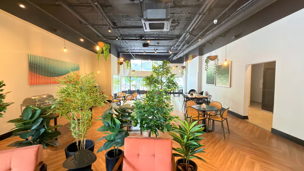 Reception and restaurant at Heritage X, with tables, plants and natural light