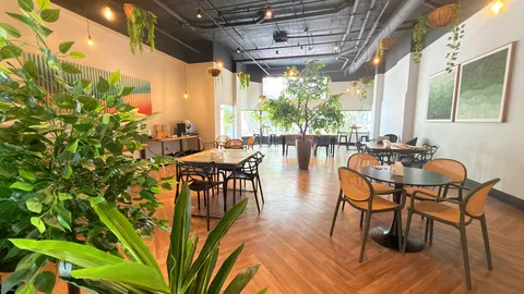Reception and restaurant at Heritage X, with tables, plants and natural light