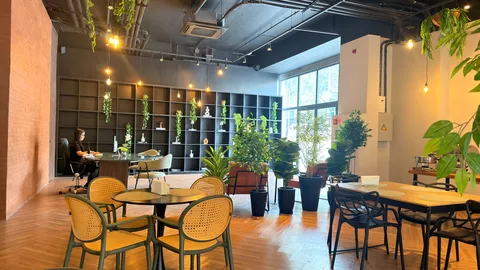 Reception and restaurant at Heritage X, with tables, plants and natural light